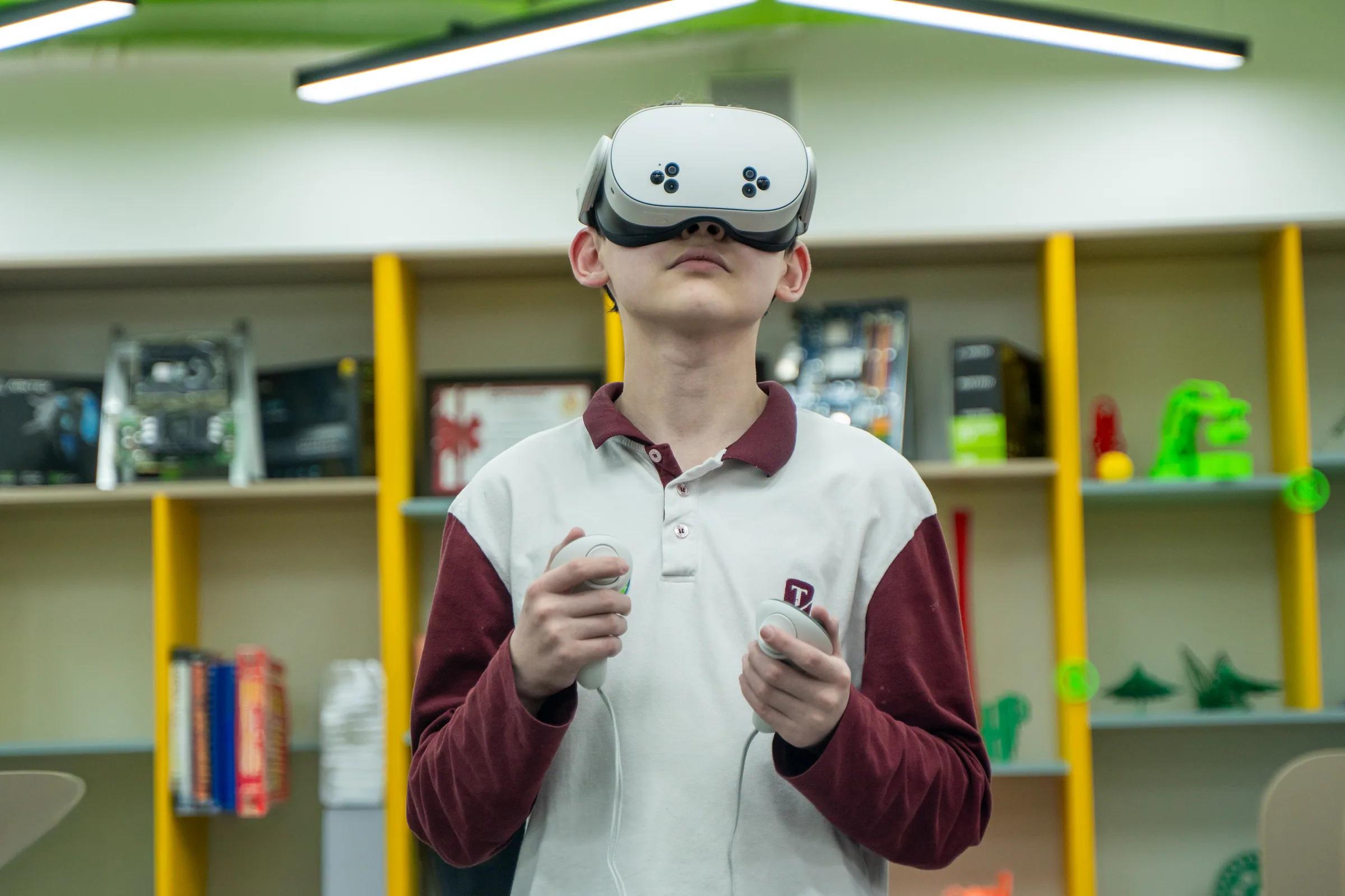 Ученик в VR-очках в кабинете робототехники